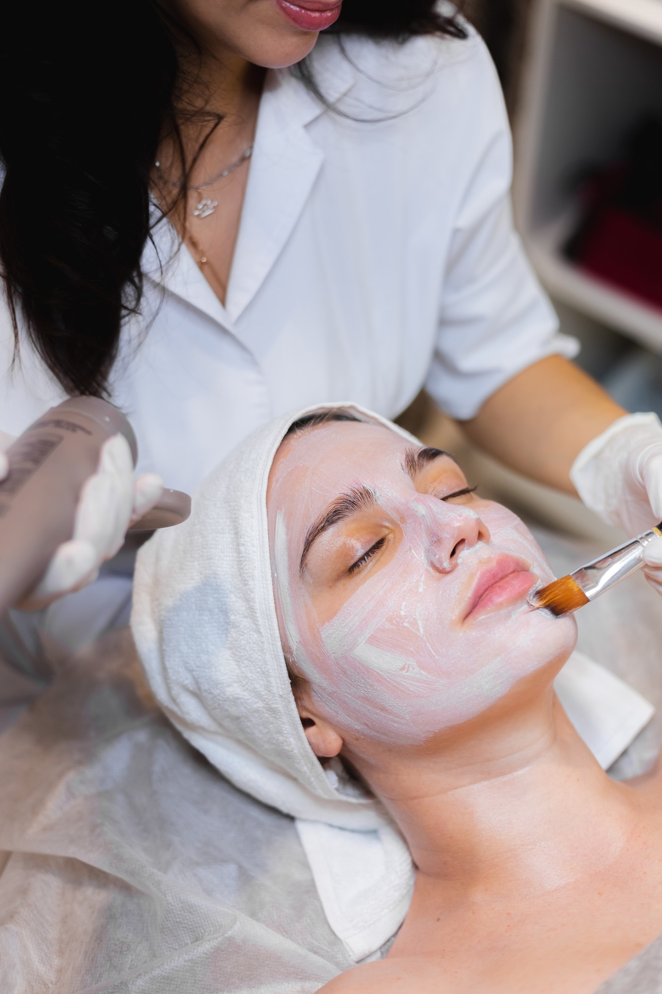 Beautician with brush applies white moisturizing mask face young girl client spa beauty salon 343596 4248